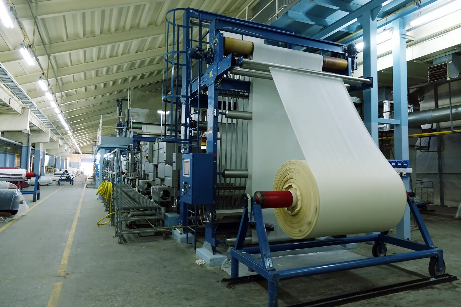 Tekstil fabrikasında kumaş topu sarma makinesi